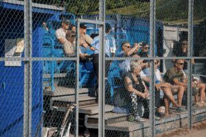 Spectators sit in blue stands at the Danish National Softball Championships 2024
